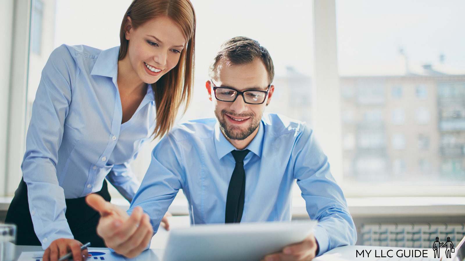 man and woman chatting at a desk