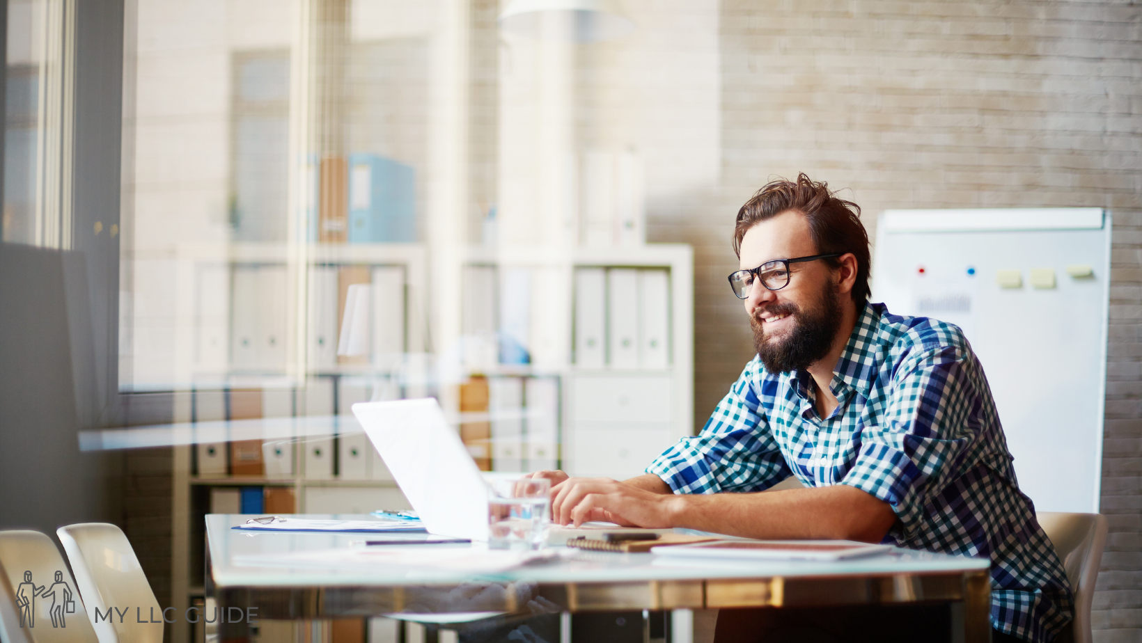 man in an office working on his laptop completing a california llc articles of organization form