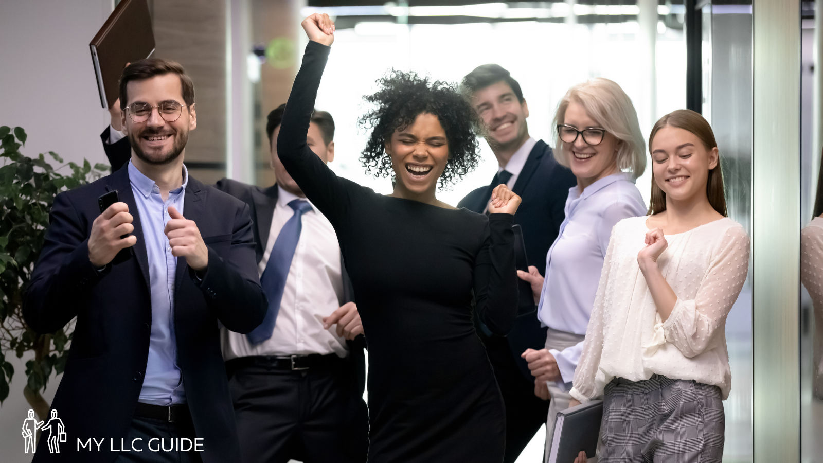 business people cheering in an office hallway