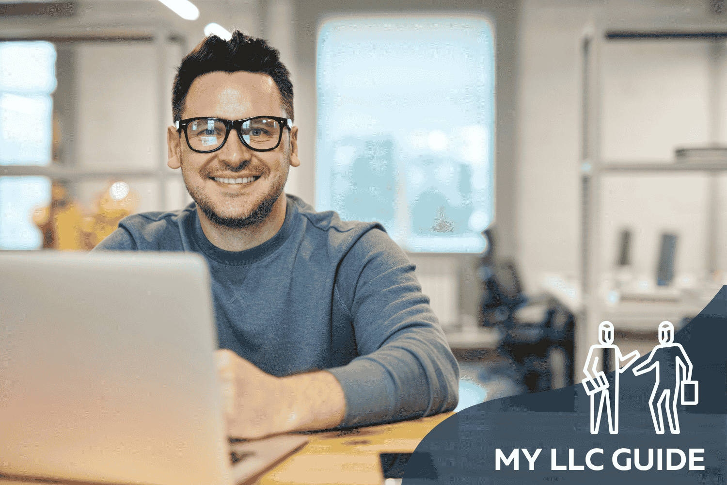 MAN WITH GLASSES WORKING ON A LAPTOP